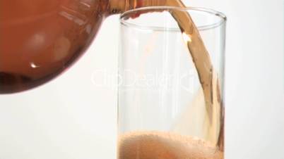 Brown fizzy drink poured in super slow motion in a glass