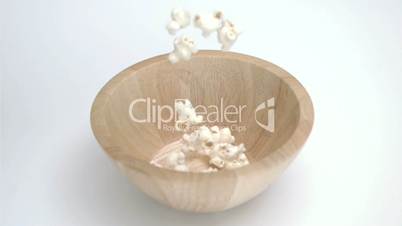 Popcorn in super slow motion falling in a bowl