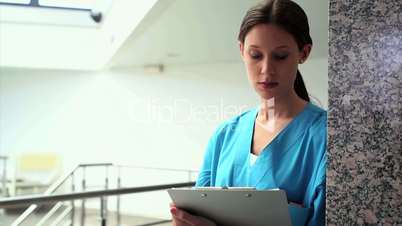 Serious nurse writing on a clipboard