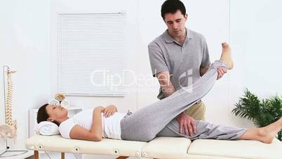 Physiotherapist stretching the leg of a woman patient