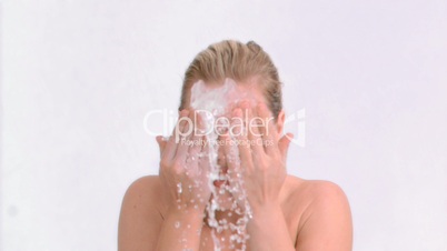 Happy woman in slow motion splashing her face