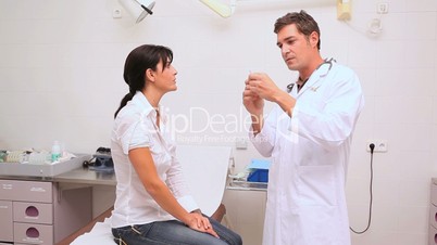 Doctor preparing a syringe and disinfecting arm of a patient