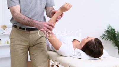 Physiotherapist manipulating the shoulder of a woman