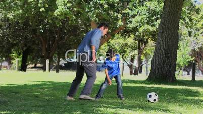 Son and his father playing football