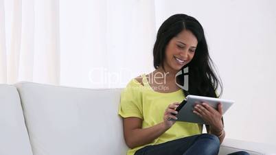 Woman sitting on a sofa while using an ebook