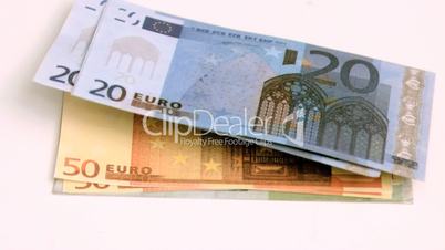 Wind blowing in super slow motion on euro banknotes