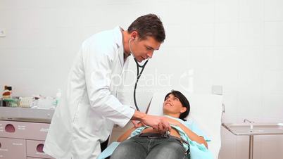 Doctor auscultating patient belly with a stethoscope