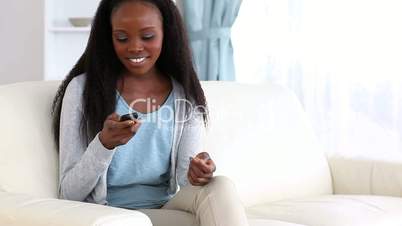 Woman sitting on sofa while talking on the phone