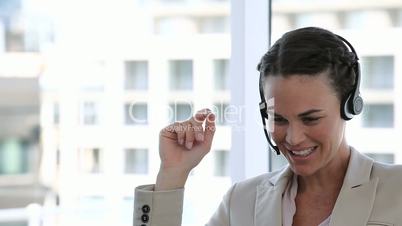 Business woman laughing while talking into a headset