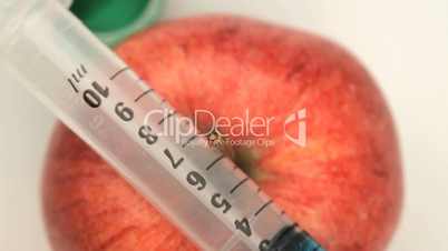 Overhead view of an apple and a syringe