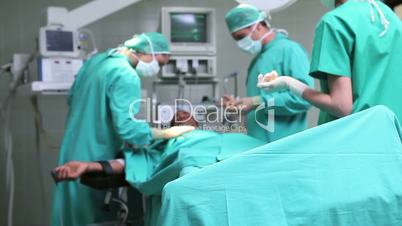 Doctors working on patient with tensiometer