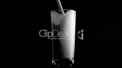 Milk in super slow motion being poured in a glass