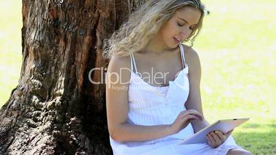 Woman sitting in a park using an ebook