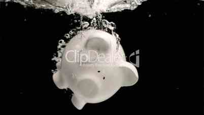 White piggy-bank diving in super slow motion into water