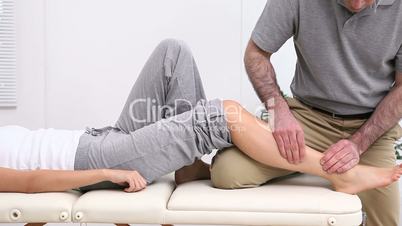Physiotherapist massaging the shin bone of a patient