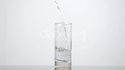 Still water poured in super slow motion in a glass