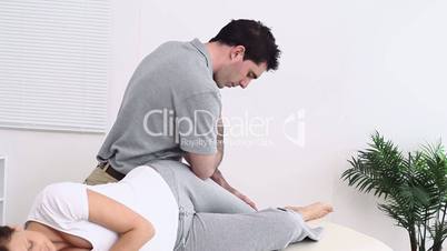 Physiotherapist using his elbow to massage the thigh of a woman