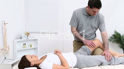 Physiotherapist massaging a knee of a patient