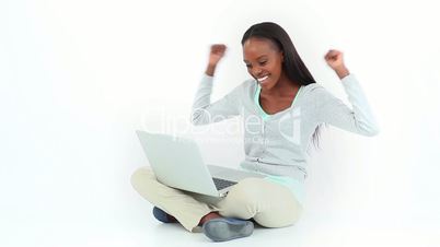 Woman celebrating while looking at a computer