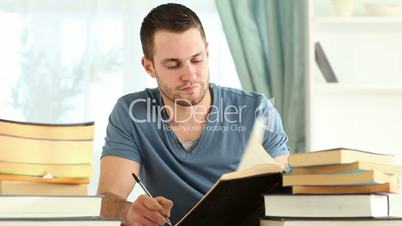 Writer taking notes while reading books