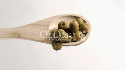 Olives falling in super slow motion from the spoon