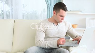 Young man using his payment card online