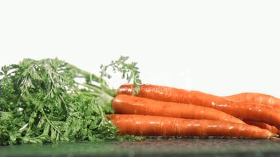 Tasty carrots in super slow motion receiving raindrops