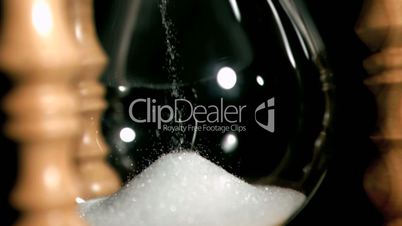 Sand dropping in super slow motion from an egg timer