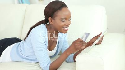 Video of a black woman holding a tablet computer and a credit card