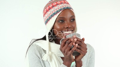 Woman with a cap drinking from a mug