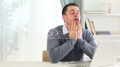 Depressed man working on a laptop