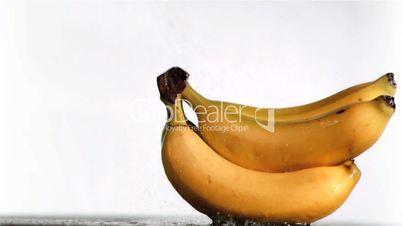 Water in super slow motion dripping on delicious bananas