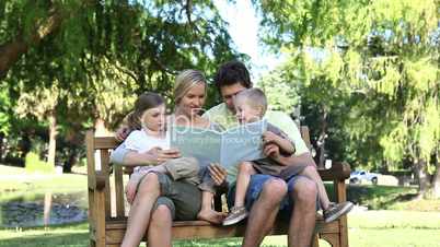 Family looking at a book in a park