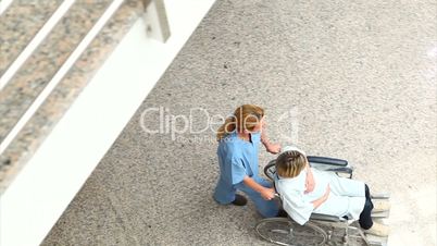 High angle view of a nurse wheeling a patient in a wheelchair