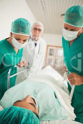 Patient lying on a medical bed next to doctors