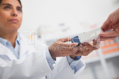 Close up of a pharmacist giving a box to someone