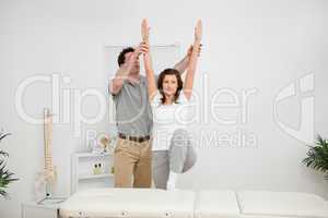 Brunette doing stretching exercises with a physiotherapist