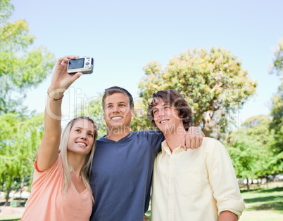 Close-up of three smiling students taking a pictures of themselv