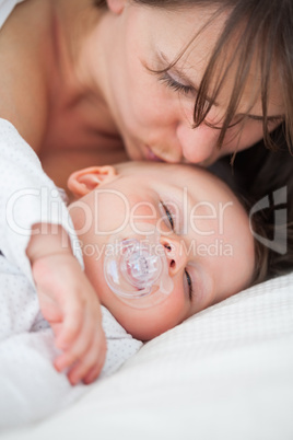 Brunette woman kissing the head of her baby