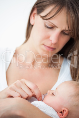 Serious woman giving a pacifier to her daughter