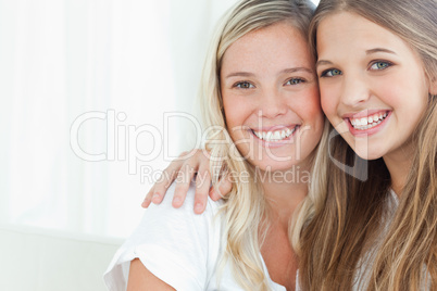 A smiling pair of sisters looking at the camera