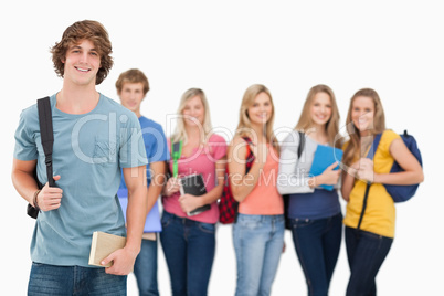 A man standing in front of his friends as he smiles