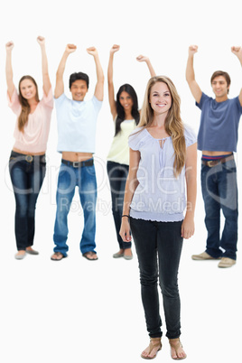 Woman smiling with people with their arms raised behind her