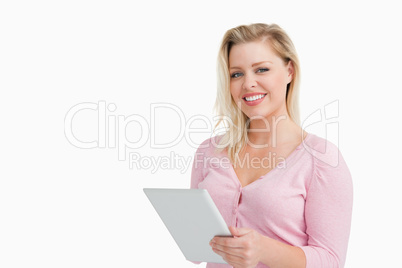 Cheerful blonde woman holding her touchscreen