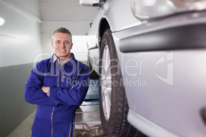 Front view of a mechanic smiling with arms crossed