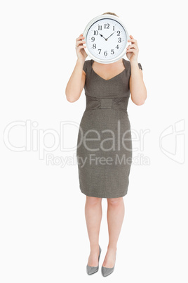 Woman holding a clock hiding her head