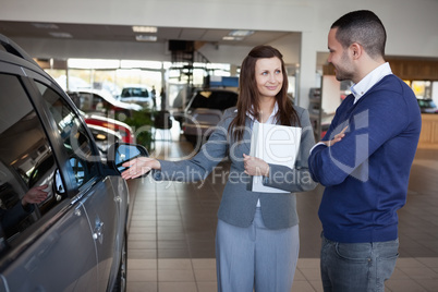 Businesswoman presenting a car to a client