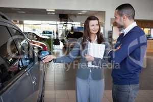 Businesswoman presenting a car to a client