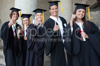 Graduates posing the thumb-up