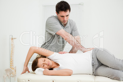 Osteopath crossing his arms while massaging a woman